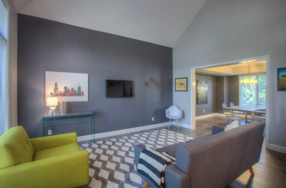A living room with a dark grey feature wall and a lime green armchair